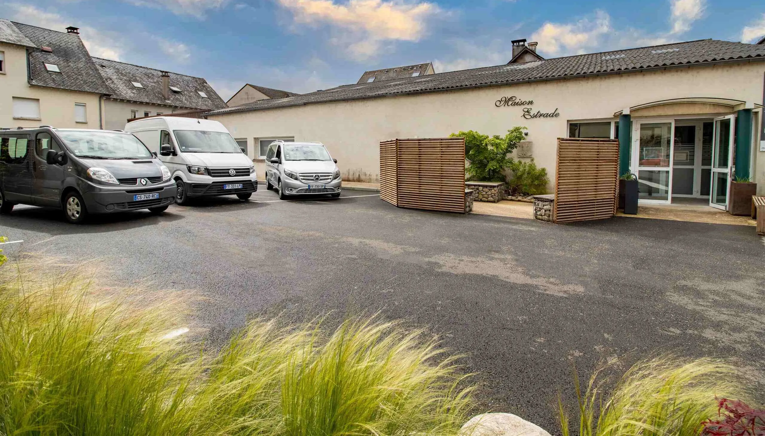 Parking de la Maison Estrade avec véhicules funéraires stationnés devant le bâtiment
