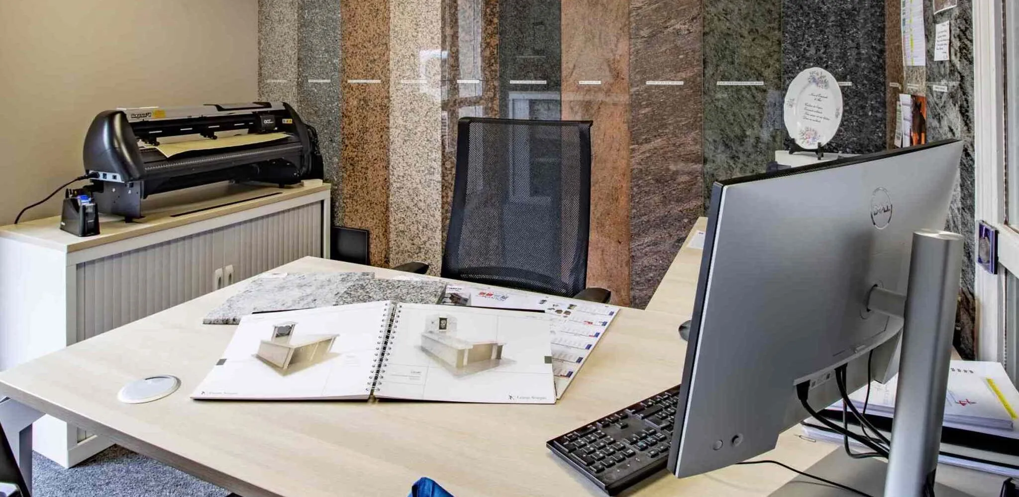 Espace de conseil en marbrerie avec échantillons de granit et catalogue sur bureau